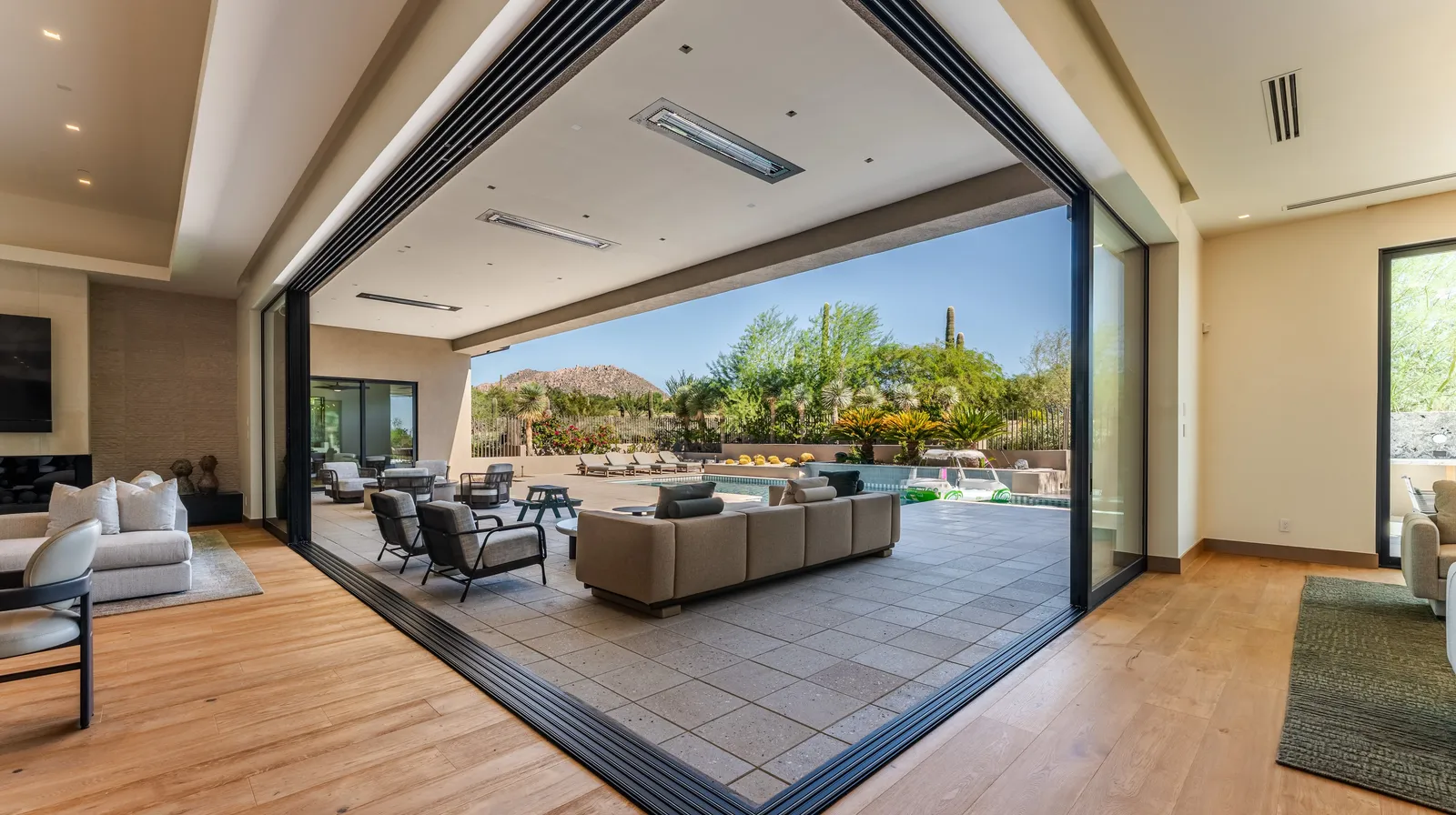 Corner-opening floor-to-ceiling glass wall in a Cave Creek estate looking toward desert landscaping Corner-opening floor-to-ceiling glass wall in a Cave Creek estate looking toward desert landscaping